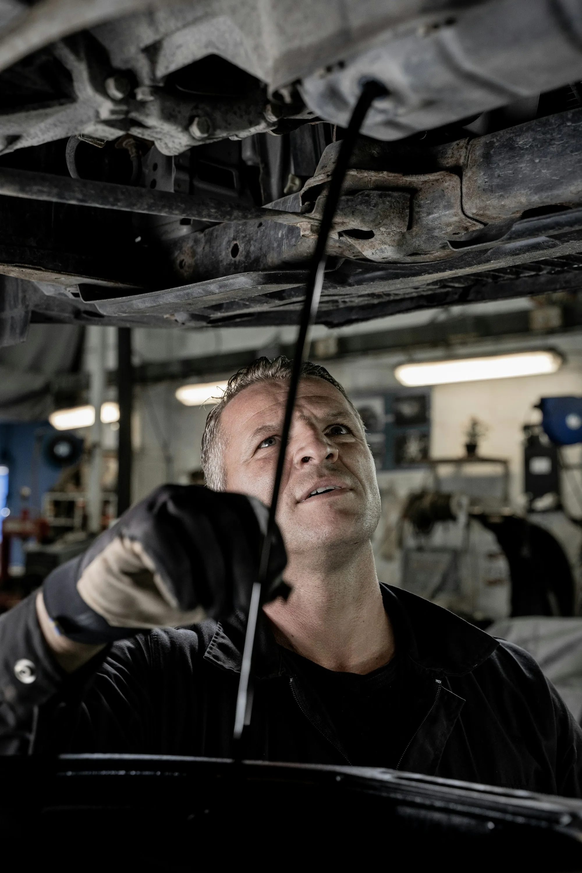 Mechanic looking up while working beneath a vehicle