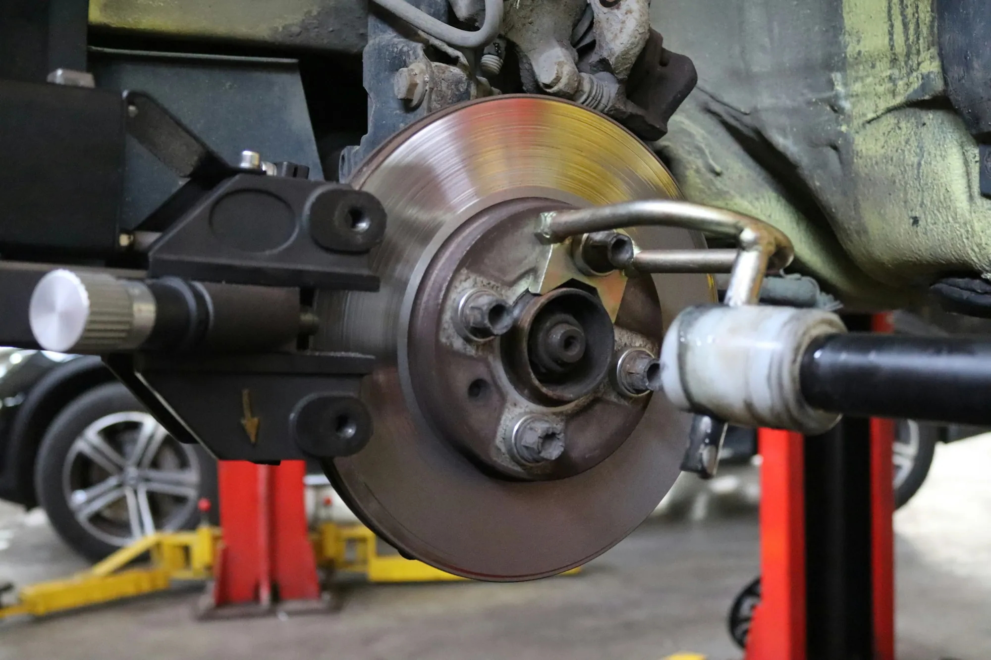 Brake disc and caliper assembly on a car raised for service