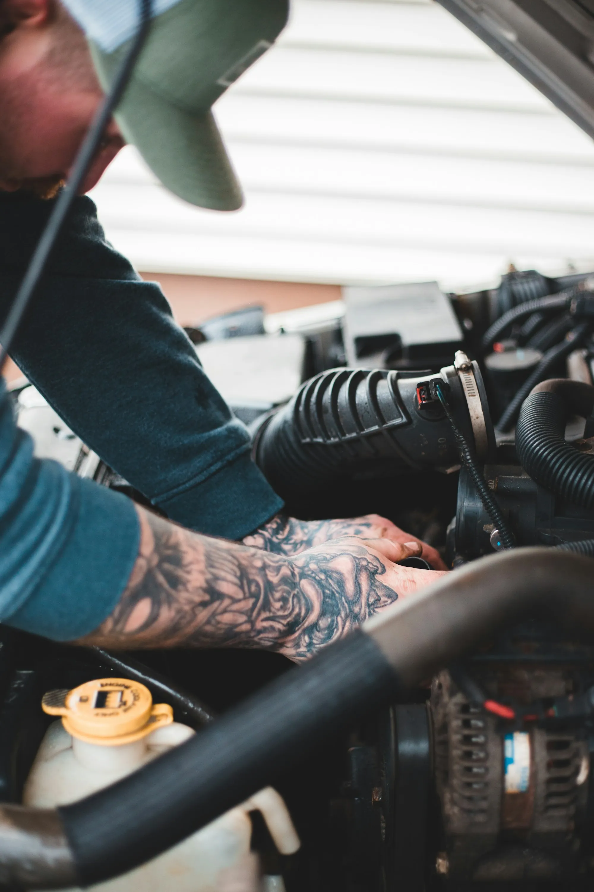 Technician leaning into an engine compartment while working