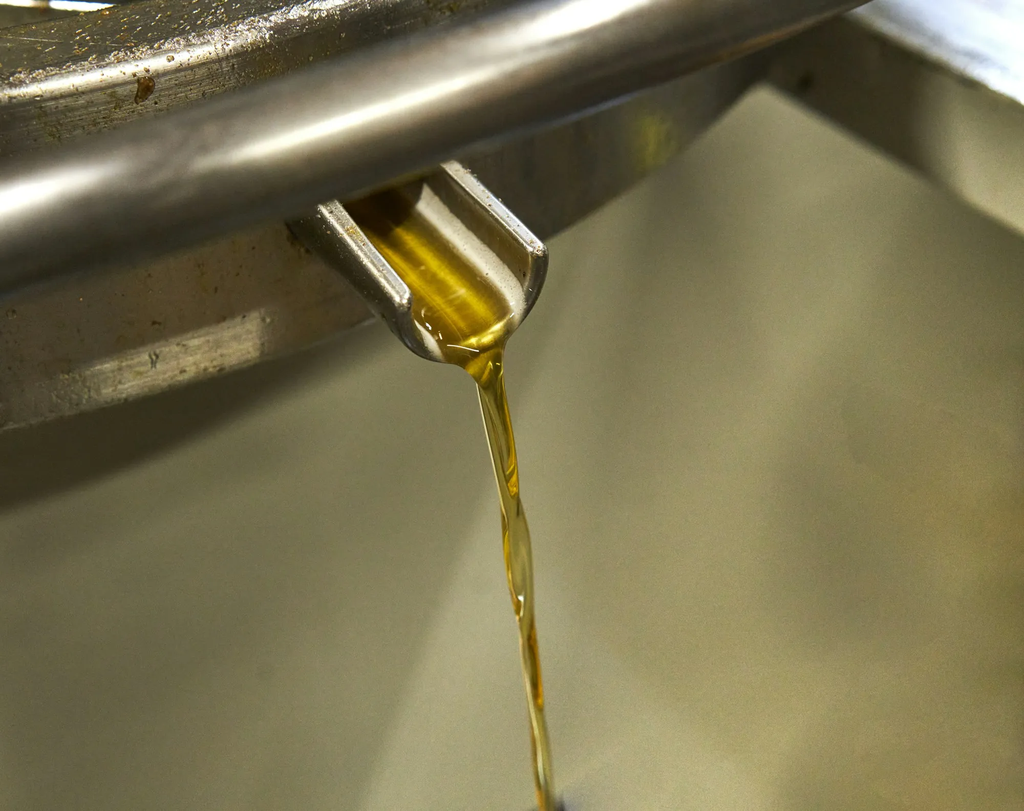 Fresh oil pouring from a bottle into an engine